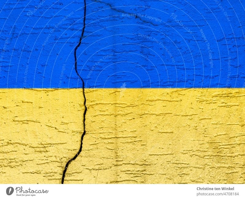 Betonmauer mit einem deutlich Riss in den Nationalfarben der Ukraine ukrainische farben Gefahr Krieg ukrainische Flagge krieg in der ukraine Hintergrund
