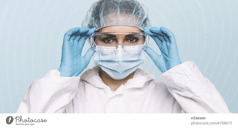 Ärztin oder Krankenschwester mit Latex-Schutzhandschuhen und medizinischer Schutzmaske und Brille im Gesicht. Schutz vor dem Coronavirus COVID-19 Krankenpfleger