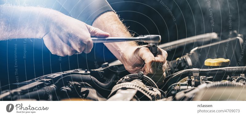 Automechaniker bei der Arbeit an einem Automotor in einer Autowerkstatt. Reparaturservice. authentische Nahaufnahme, Bannergröße PKW Mechaniker Garage Fett