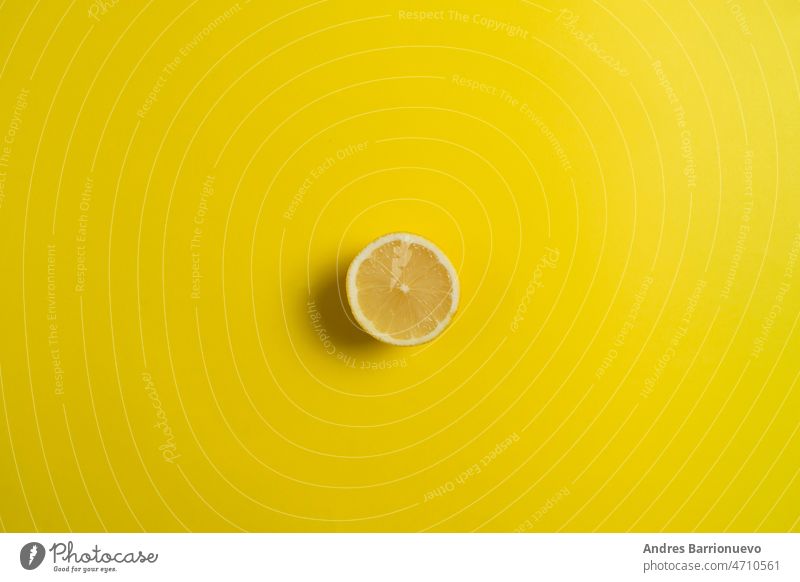 Zitrone auf leuchtend gelbem Hintergrund. Minimales Sommer-Konzept. Flach legen. Bestandteil Zitrusfrüchte Saft saftig organisch Makro roh reif geschnitten