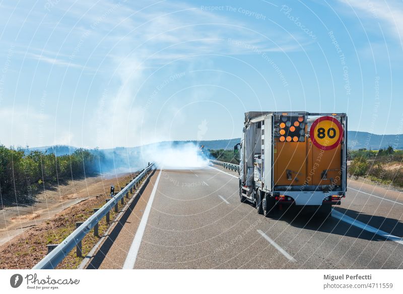 Lackiermaschine der Linien der Straße, die bei der Arbeit eine Rauchwolke bilden. Malerei Lastwagen Markierungen Flugzeugwartung Fahrbahn Spezialfahrzeug Gefahr