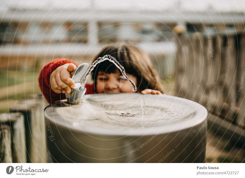 Niedliches Kind spielt mit Park Trinkbrunnen niedlich trinken Springbrunnen Wasser Außenaufnahme nass Kindheit Freude Tag Wasserfontäne Erfrischung Farbfoto