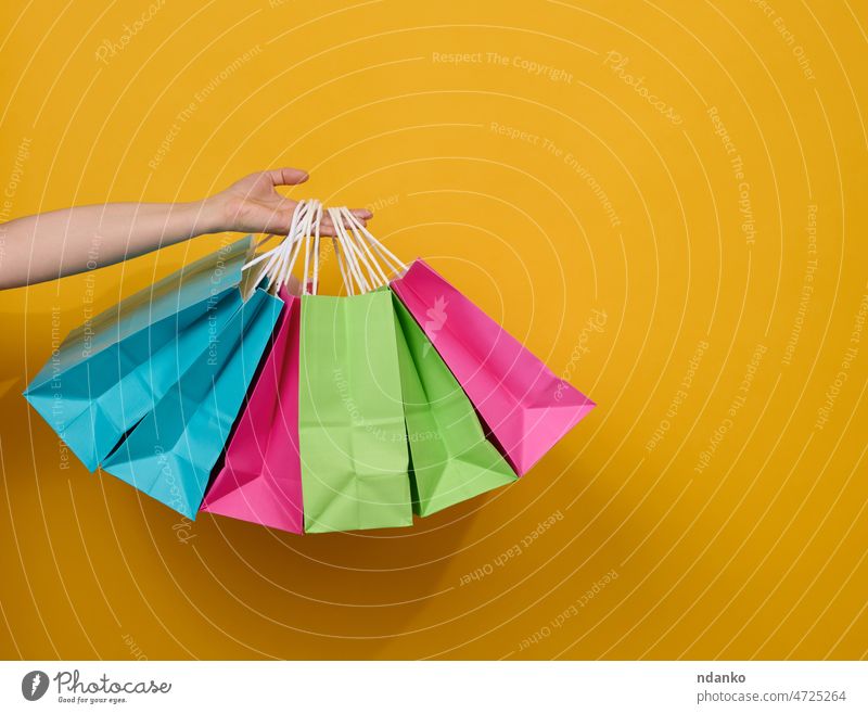 Die weibliche Hand hält eine Einwegtasche aus Papier mit Griffen für Lebensmittel und Kleidung. Wiederverwertbare Verpackung. Null Abfall. Verkauf Arme