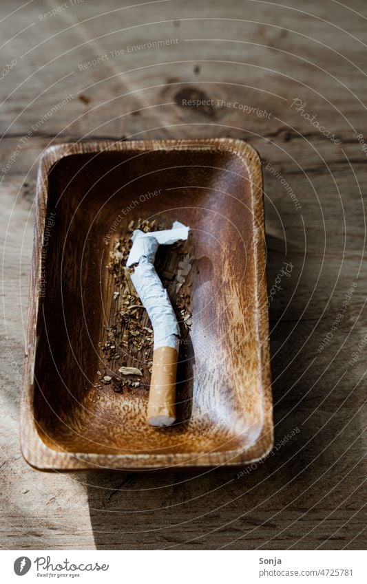 Eine zerbrochene Zigarette in einem Aschenbecher. kaputt Zerstörung ungesund Gefahr Rauchen gesundheitsschädlich Sucht Abhängigkeit Suchtverhalten Tabakwaren