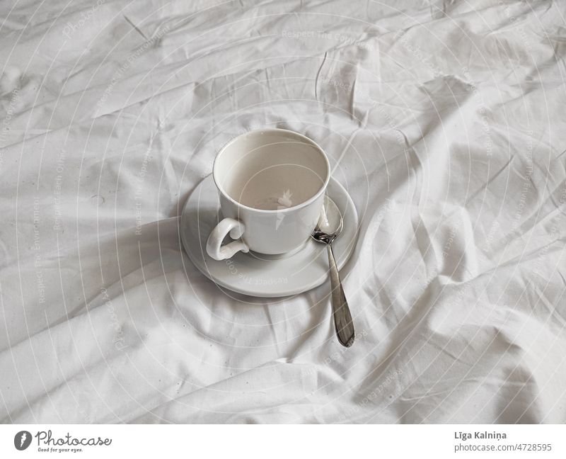 Weiße Tasse auf weißem Teller auf weißem Bettlaken Frühstück Kaffee Getränk Kaffeetrinken genießen Kaffeebecher Nahaufnahme Heißgetränk Lebensmittel weiße Decke