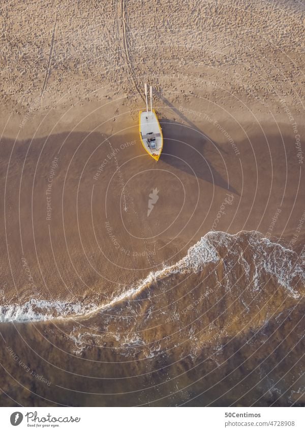 Einsames Fischerboot am Strand Drohnenansicht Luftaufnahme Blick nach unten Küste Boot Ruderboot gelb Sand Sandstrand Wellen Meer Schatten Sonnenlicht
