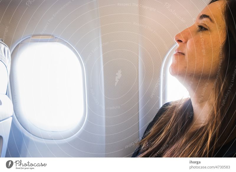 Junge Frau sitzt in Flugzeugsitz am Fenster Erwachsener Air Fluggerät Fluggesellschaft Flughafen schön Business Kabine lässig bequem Fliege Mädchen Feiertag