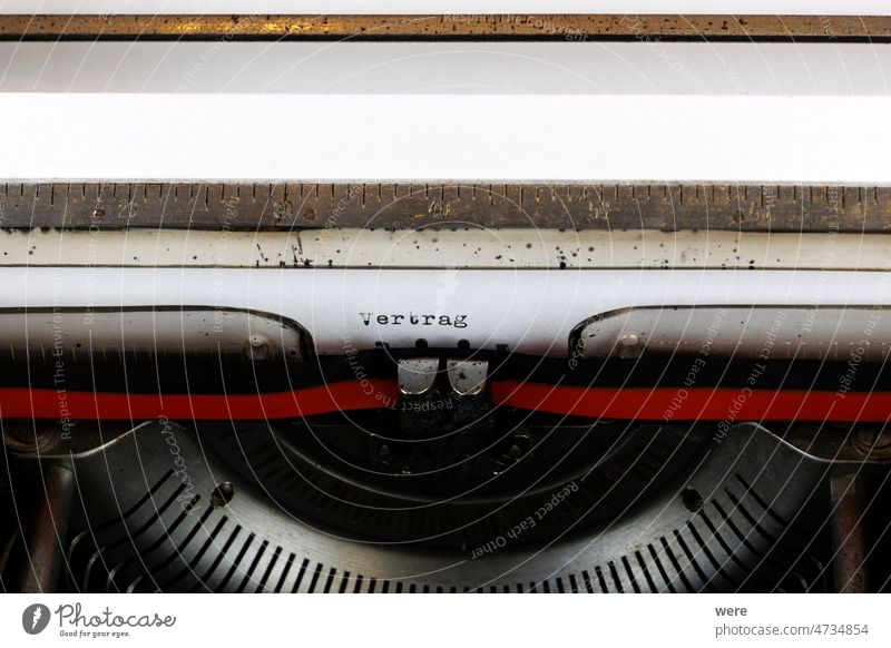 Das deutsche Wort Vertrag, geschrieben auf einer alten mechanischen Schreibmaschine Auftrag Hier klicken Brief stoppen antik schwarz Vertragsrecht