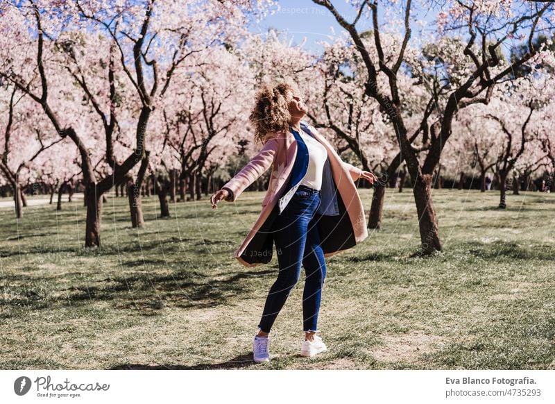 Kurvige glückliche hispanische Frau mit geschlossenen Augen im Park tanzen am sonnigen Tag. Frühling. Körperliche Positivität Tanzen kurvenreich