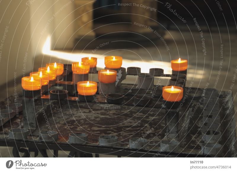 Kerzen anzünden Kerzenständer Opferlichttisch Metall Kerzenhalter Teelichtständer Teelichter Docht Flamme Lichteinfall Kirche Fenster halbdunkel