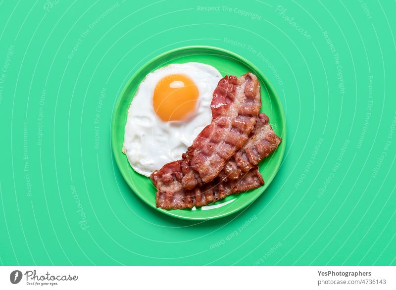 Spiegelei und Speck auf grünem Hintergrund, Ansicht von oben Frühstück hell Hähnchen Cholesterin Farbe Essen zubereiten Textfreiraum Küche lecker Design