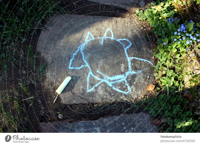 Zeichnung einer Sonne oder Blume, mit Kreide auf einer Steinplatte gemalt Malkreide malen Kreativität Straßenkreide Strassenmalerei Kinderspiel Kindheit