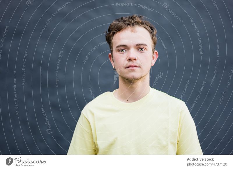 Junger Mann schaut in die Kamera im Studio Vorschein Model Kurze Haare Individualität Stil Persönlichkeit braune Haare Atelier Porträt männlich grüne Augen