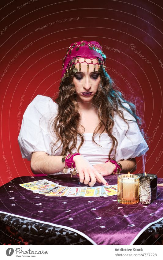 Weibliche Wahrsagerin, die auf Tarotkarten zeigt Frau Postkarte Zauberei u. Magie vorhersagen Kerze erraten Porträt Zukunft übernatürlich mystisch Esoterik