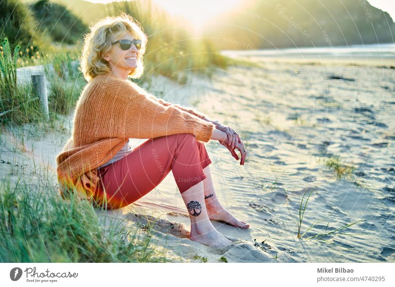 Junge reife blonde kaukasische Frau, die sich an einem sonnigen Tag mit einem Tablet im Freien entspannt. Lifestyle Porträt Frauen Gesundheit eine Person