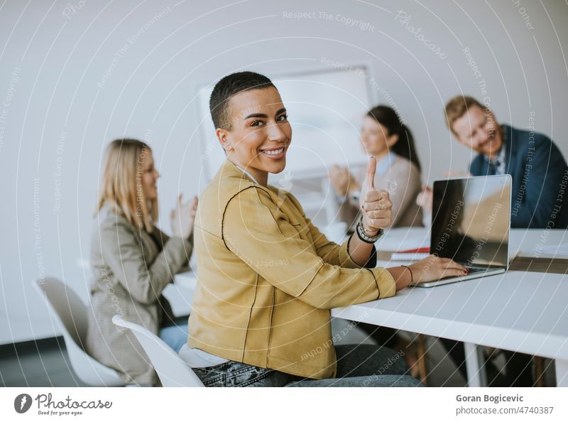 Junge kurzhaarige Geschäftsfrau sitzt im Büro und benutzt einen Laptop mit ihrem Team Erwachsener attraktiv Business Karriere Kaukasier korporativ Unternehmer