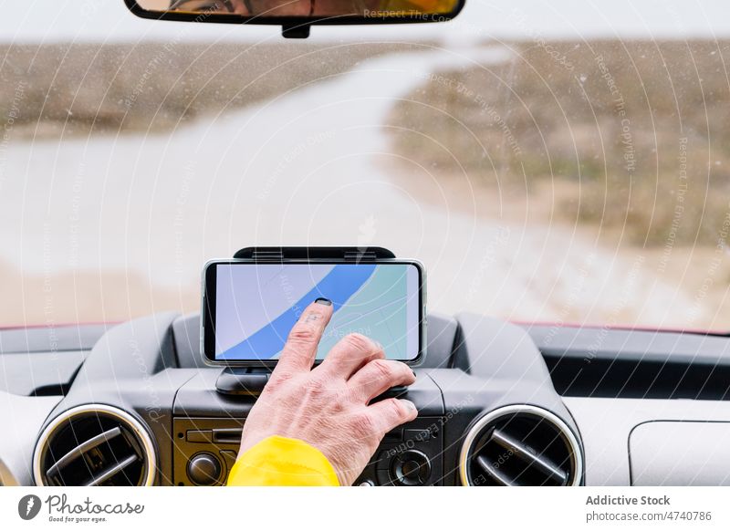 Unbekannter Mann schaltet GPS im Auto ein PKW Gps Smartphone Navigator Fahrer Landschaft Autoreise Straße Regie Automobil Windschutzscheibe Fahrbahn Fahrzeug