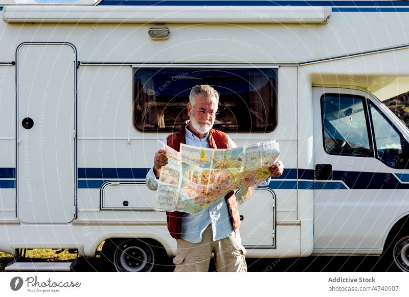 Älterer Mann mit Karte in der Nähe des Wohnwagens Wohnmobil PKW rv Natur Autoreise Senior Landkarte navigieren prüfen reif Reise Feld Anhänger Landschaft