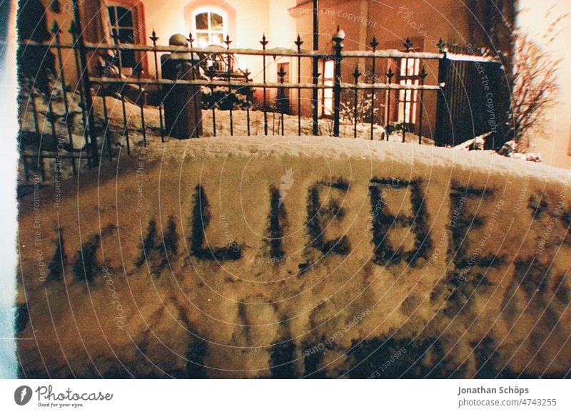 Ich liebe geschrieben in Schnee am Auto nachts ich liebe dich Liebe liebesbotschaft Botschaft Schriftzeichen Text Schneedecke Außenaufnahme Straße analog retro