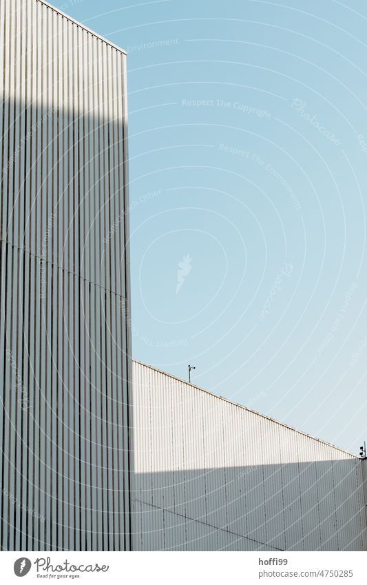 Weisse Wellblechfassaden einer Lagerhalle im Hafen vor blauem Himmel Architektur Industriefassade Blauer Himmel Schuppen minimalistisch Hafengebäude