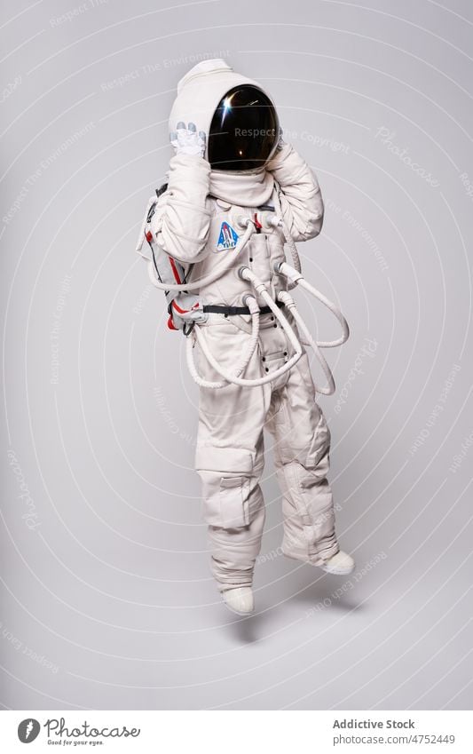 Anonymer Astronaut in Raumanzug und Helm im Studio Schutzhelm Sicherheit Atelier Weltall Wissenschaft Schmuckkörbchen erkunden Missionsstation Person Pilot