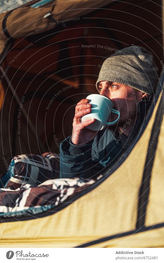 Mann trinkt Heißgetränk im Campingzelt bei Sonnenaufgang Wohnmobil Zelt Morgen Kaffee bewundern sich[Akk] entspannen Erholung Freiheit männlich Reisender