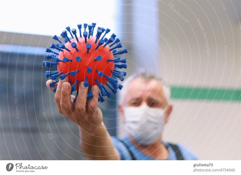 Das Corona-Virus aus der Werkstatt | Mann mit Maske hält stolz das Virus in seiner Hand 3D corona thoughts covid-19 Handarbeit selbstgemacht gefährlich