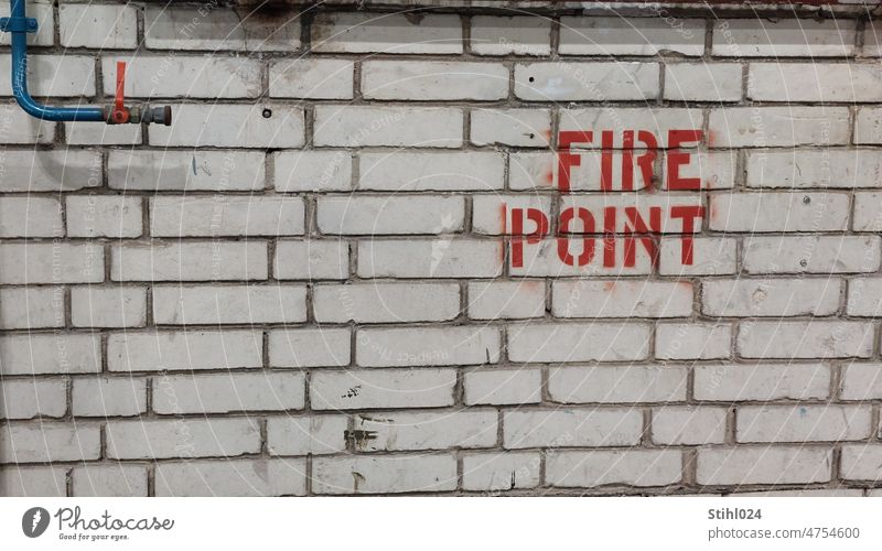 Schriftzug "FIRE POINT" auf weißer Ziegelwand fire point Feuer Kalksandstein Mauer Wasserhahn Ventil Wasserleitung Brandschutz Vorsicht Schutz feuerwehr