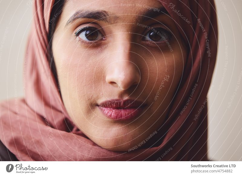 Porträt einer jungen muslimischen Frau, die einen Hidschab trägt und mit nachdenklichem Gesichtsausdruck in Richtung Kamera schaut nahöstlich Hijab besinnlich