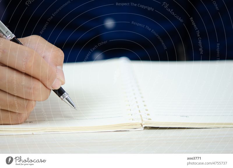 Nahaufnahme, die einen Stift hält und in ein Notizbuch schreibt. Notebook Schreibstift Business Papier Schreibtisch Büro Bildung Tagebuch Person Beteiligung