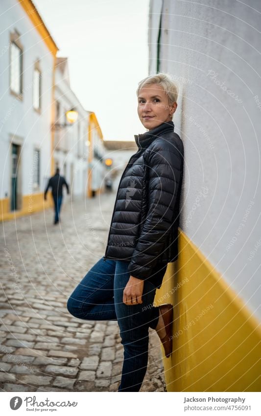 Porträt einer blonden modernen Frau in städtischer Umgebung Großstadt urban Lebensmitte Faro historisch entspannend Stehen Stadtzentrum Gebäude Fröhlichkeit