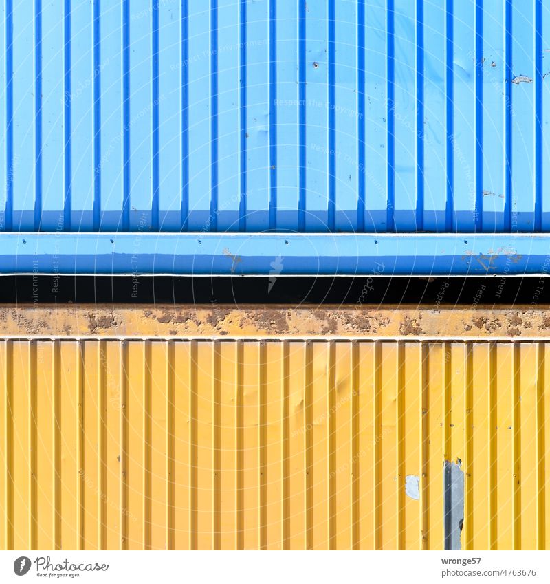 Nahaufnahme zweier aufeinander gestapelten Container Baustelle übereinandergestapelt übereinanderliegend blau und gelb Baucontainer Metall Außenaufnahme