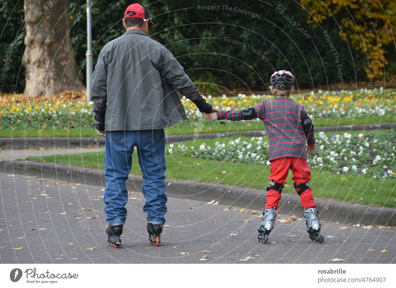hinterrücks | Vater und Sohn beim Skaten Hand in Hand Freizeit & Hobby Inline skates Vatertag Sport Freude Inline Skating Rollschuhfahren lernen Spielen