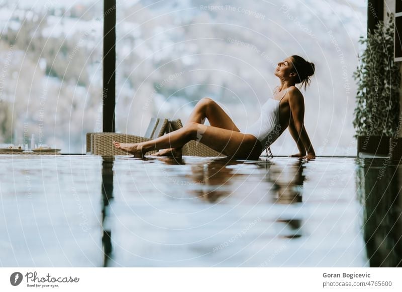Junge Frau entspannt sich am Rande des Infinity-Pools im Winter 20s Erwachsener attraktiv Schönheit Bikini Körper brünett Kaukasier genießen Genuss passen