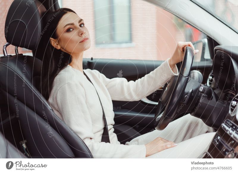 Foto einer glücklichen jungen Frau, die in ihrem neuen Auto sitzt. Konzept für Autovermietung PKW Sitzen Miete im Inneren Fahrzeug Menschen Besitzer Transport