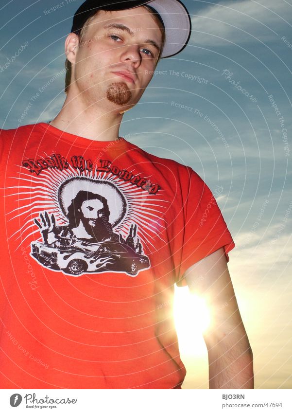 Alex im Gegenlicht #2 Mütze Baseballmütze Kopfbedeckung schwarz Wolken Sonnenuntergang Kerl Mann T-Shirt Jesus Christus Bart Freiheit Porträt Außenaufnahme