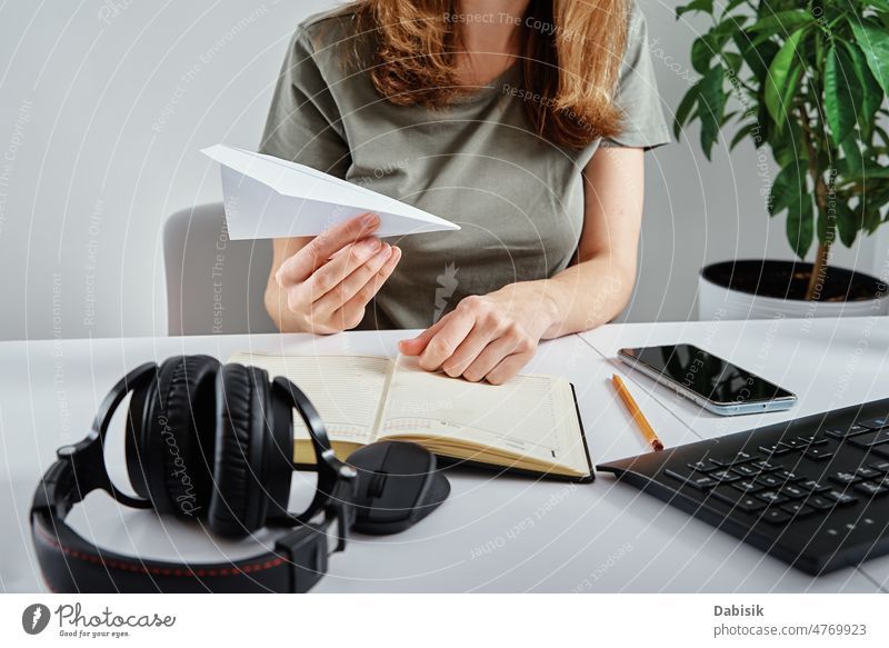 Frau spielt mit Papierflugzeug am Arbeitsplatz LAZY Abgelenkt Zögern Heimarbeitsplatz unergiebig abgelegen Büro vermeiden gelangweilt Business Mitteilung