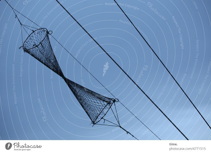 trocknende Fischreuse am Seil vor dunklem Himmel in Schräglage fischreuse seil himmel hängen parallel netz gewebt struktur fischfang maritim kegelförmig wolken