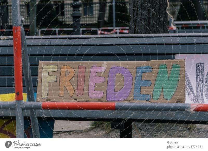 Schild auf einer Bank hinter Absperrungen, Aufschrift Frieden Demonstration friedensdemo Berlin Solidarität Politik & Staat Menschlichkeit protestieren Krieg