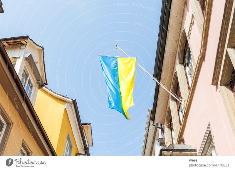 An einem Haus in der Lindauer Altstadt hängt eine ukrainische Flagge als Zeichen der Solidarität Russland Ukrainer Bayern blau Gebäude Textfreiraum Fahne