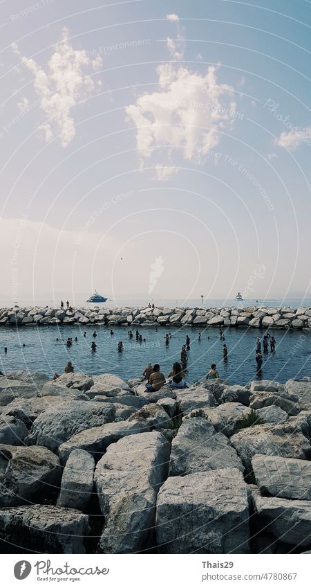 Ruhiges blaues Tyrrhenisches Meer. Blick von der Uferpromenade Neapels auf den Vulkan Vesuv. Stein Wellenbrecher Kurven entlang dem Meer Küstenlinie Hintergrund
