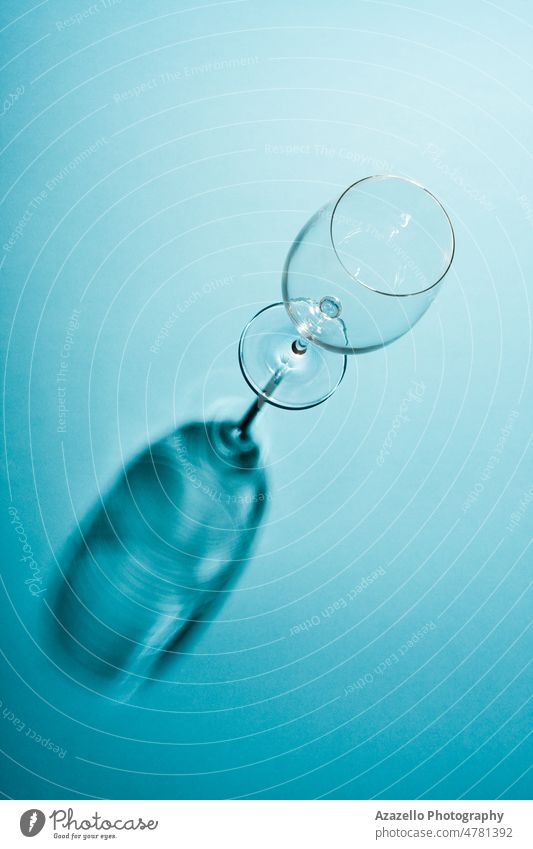 Leeres Weinglas mit einem kreativen Schatten auf blauem Hintergrund. abstrakt Alkohol Kunst Bar Basis Getränk Bordeaux-Wein Burgunder Cabernet Feier Champagne