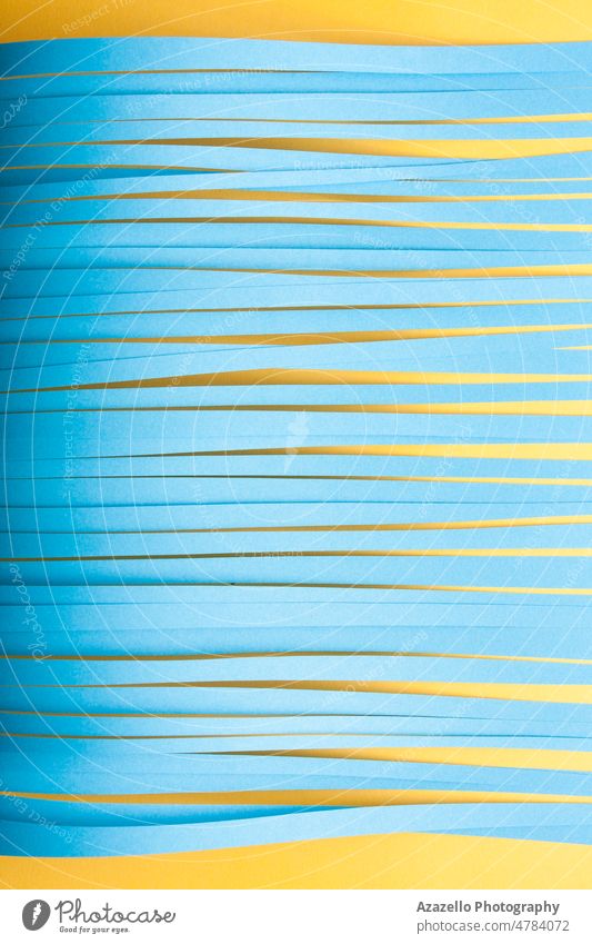 Minimalistische geschnittene Papierspitzen Hintergrund in blauen und gelben Farben. Streifen Minimalismus Stillleben abstrakt Linien ruhend Kutter Messer Textur