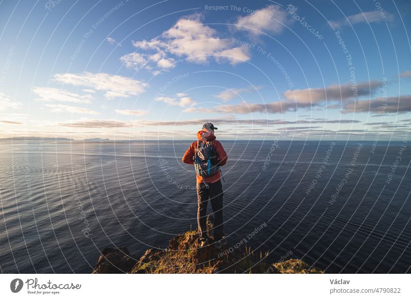 Ein leidenschaftlicher 24-jähriger Rucksacktourist steht am Rande einer Klippe in einem Ort namens Cristo Rei, Camara de Lomos, Madeira, das zu Portugal gehört. Sonnenaufgang an der Atlantikküste