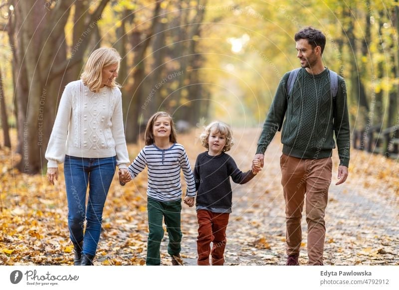 Eltern mit Kindern bei einem Spaziergang im Park laufen rennen Blatt Natur Feld Herbst fallen Mann Papa Vater Frau Mutter Familie Verwandte Sohn Junge