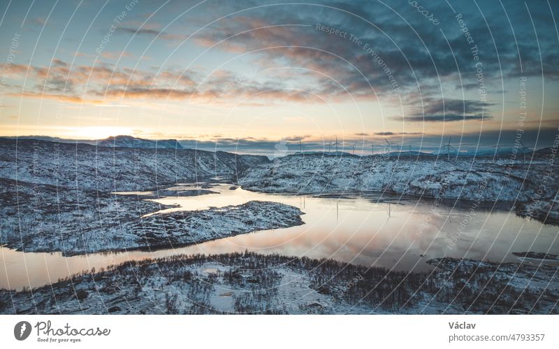 Sonnenuntergang über einer kargen norwegischen Berglandschaft in der Region Finnmark in Nordnorwegen, oberhalb des Polarkreises. Der See nedre Jernvatnet in Nordland