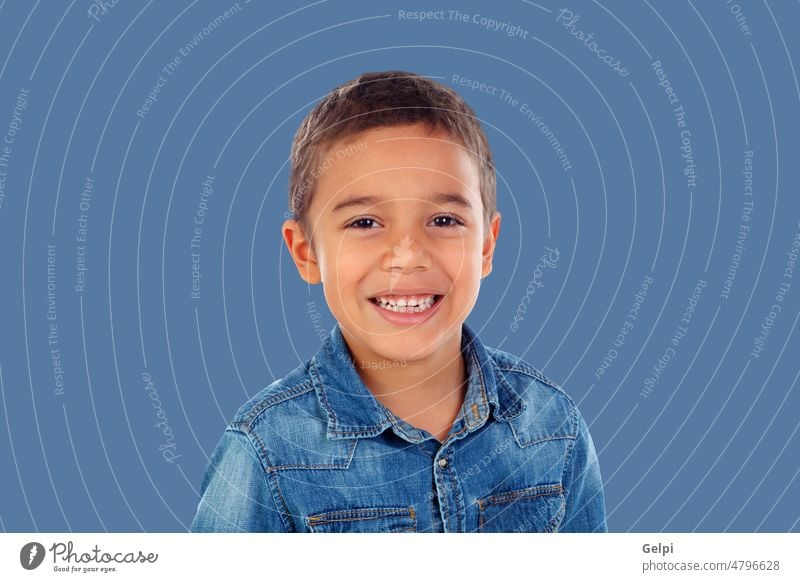 Lateinisches Kind mit Jeanshemd schaut in die Kamera und lacht Person Junge Glück vereinzelt Kindheit niedlich blau Lächeln männlich Porträt jung Hintergrund