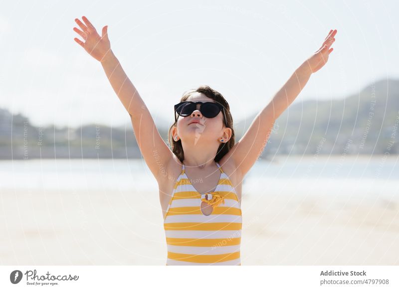 Mädchen mit Sonnenbrille am Ufer Kind Strand Sommer Küste Kindheit ruhen Zeitvertreib Erholung nackter Torso ohne Hemd Arme hochgezogen Freizeit niedlich