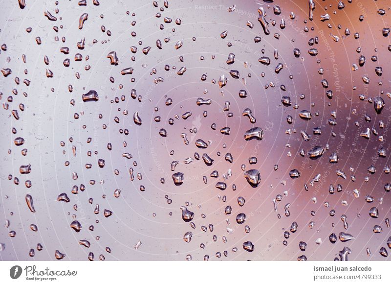 Regentropfen auf dem Fenster an regnerischen Tagen Tropfen Wasser nass Glas durchsichtig Oberfläche Nahaufnahme abstrakt Hintergrund texturiert hell