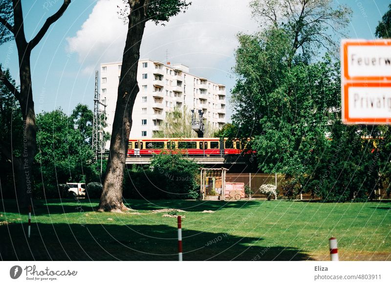 [hansa BER 2022] Bahn der BVG fährt über eine Brücke im Berliner Hansaviertel U-Bahn ÖPNV Öffentlicher Nahverkehr Schienen Wohngebiet Park grün draußen Bäume